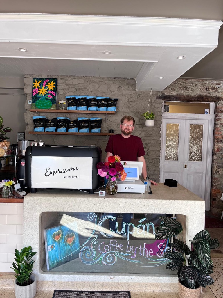 A member of the Cupán C family behind the café counter in Bunmahon